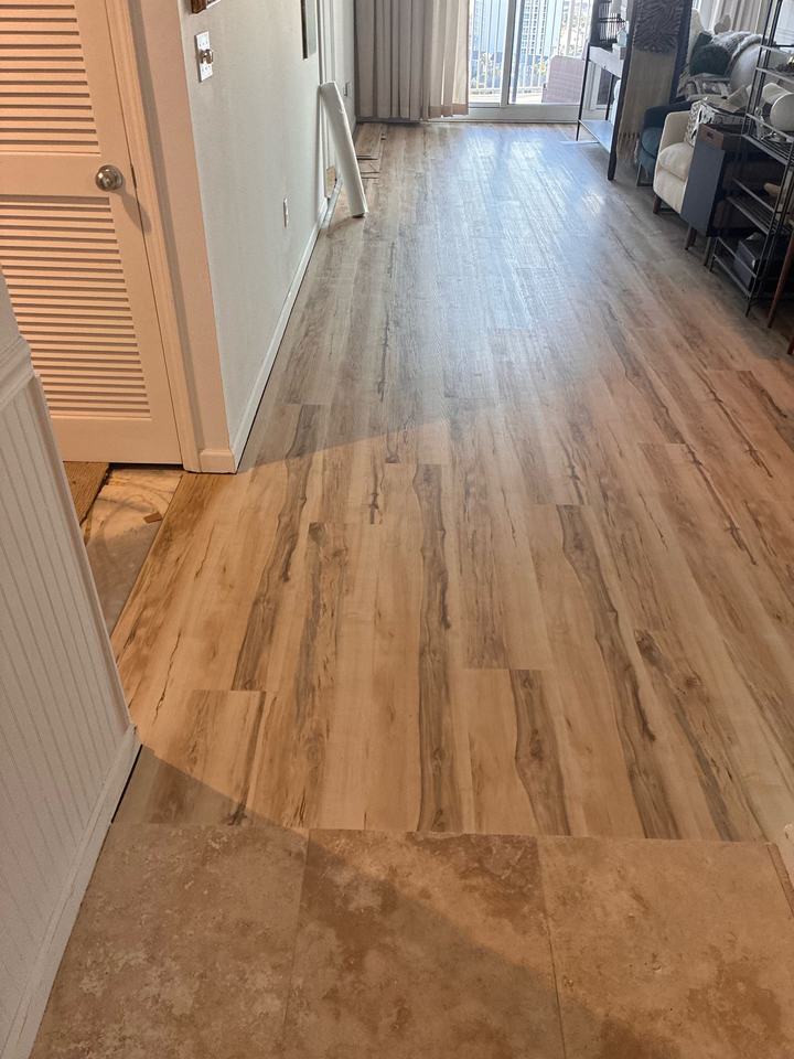 Plank flooring transitioning to stone tile