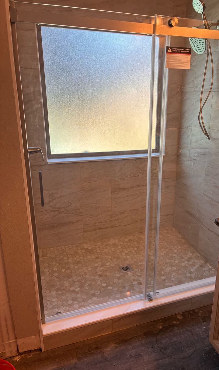 12x24 cream tile shower with sliding glass door